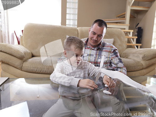 Image of father and son assembling airplane toy