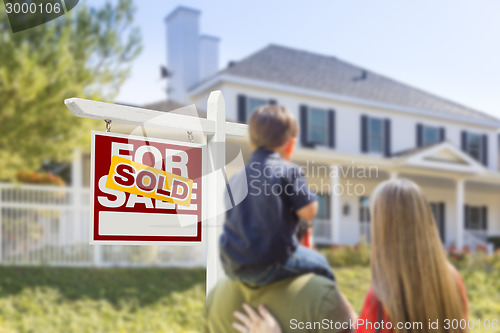 Image of Family Facing Sold For Sale Real Estate Sign and House