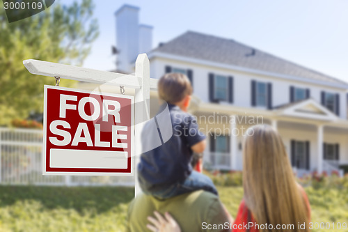 Image of Family Facing For Sale Real Estate Sign and House