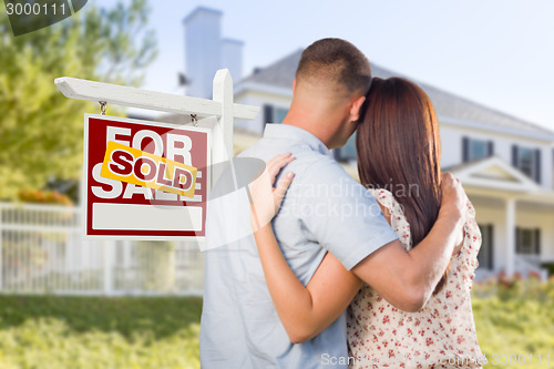 Image of Sold For Sale Sign with Military Couple Looking at House