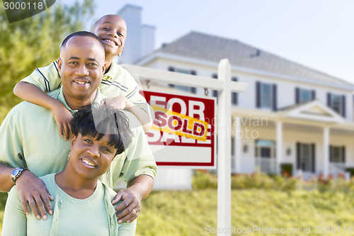 Image of African American Family In Front of Sold Sign and House