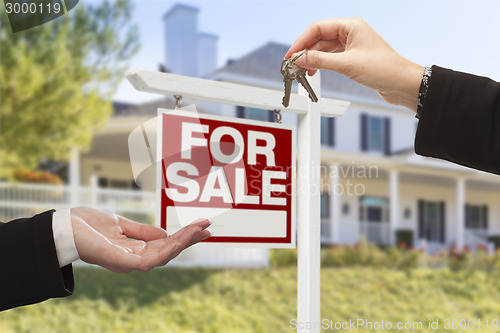 Image of Agent Handing Over House Keys in Front of New Home