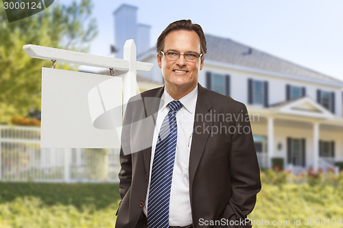 Image of Male Real Estate Agent in Front of Blank Sign and House