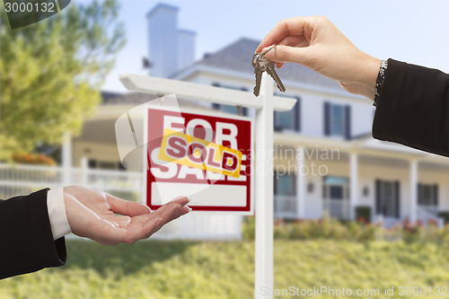 Image of Sold Sign and Agent Handing Over Keys to New Home