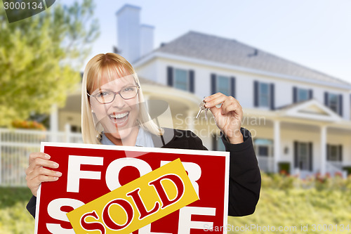 Image of Excited Woman Holding House Keys and Sold Real Estate Sign