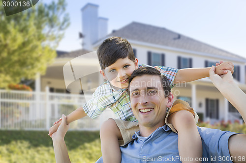 Image of Mixed Race Father and Son Piggyback in Front of House