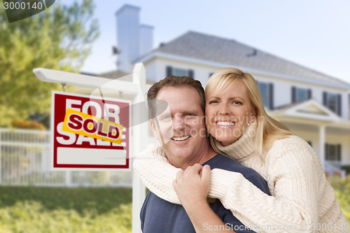 Image of Couple in Front of New House and Sold Sign