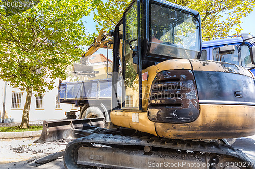 Image of Excavator loading dumper truck.