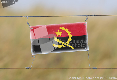 Image of Border fence - Old plastic sign with a flag