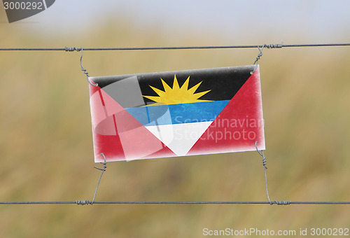 Image of Border fence - Old plastic sign with a flag