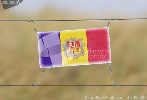 Image of Border fence - Old plastic sign with a flag