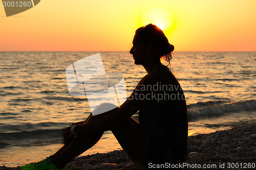 Image of The silhouette of the girl on the beach in the sun.