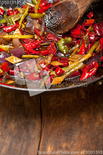 Image of fried chili pepper and vegetable on a wok pan
