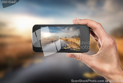 Image of Phone in hand and landscape