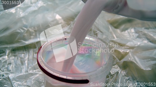Image of Pouring prime coat into the plastic bin