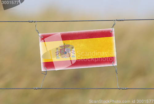 Image of Border fence - Old plastic sign with a flag