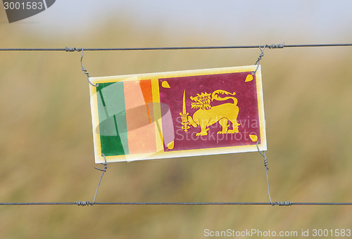 Image of Border fence - Old plastic sign with a flag