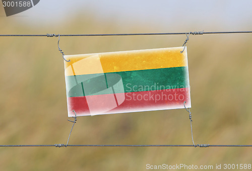 Image of Border fence - Old plastic sign with a flag