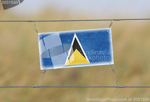 Image of Border fence - Old plastic sign with a flag