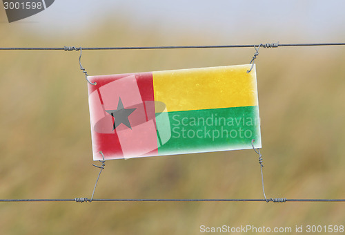 Image of Border fence - Old plastic sign with a flag