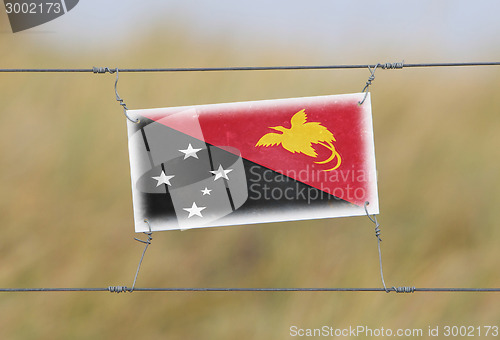 Image of Border fence - Old plastic sign with a flag