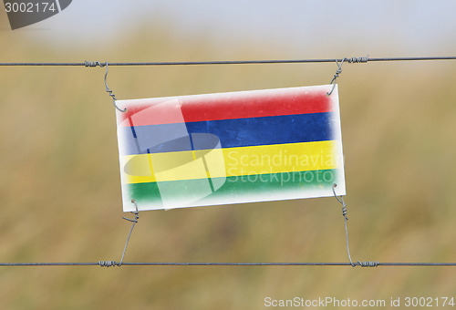 Image of Border fence - Old plastic sign with a flag