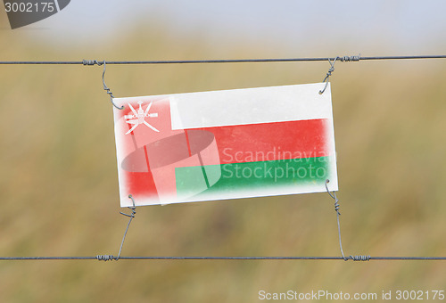 Image of Border fence - Old plastic sign with a flag