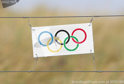 Image of Border fence - Old plastic sign with a flag