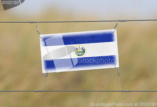 Image of Border fence - Old plastic sign with a flag