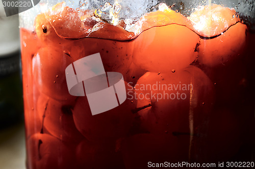 Image of glass jar with canned apples sunlit