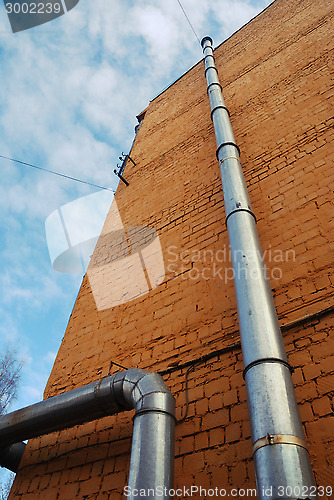 Image of two ventilation pipes on a brick wall