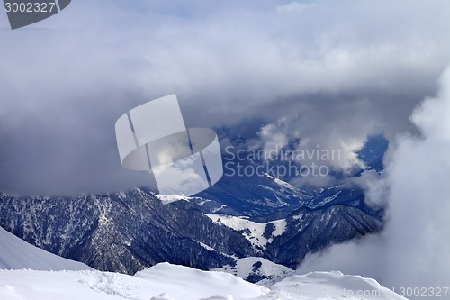 Image of Top view on winter snowy mountains in clouds