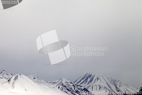 Image of Gray snowy mountains in mist