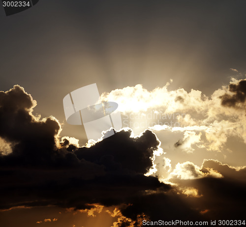 Image of Sunset sky with dark clouds and sun rays