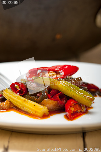 Image of fried chili pepper and vegetable on a wok pan