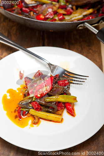 Image of fried chili pepper and vegetable on a wok pan