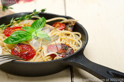 Image of spaghetti pasta with baked cherry tomatoes and basil 