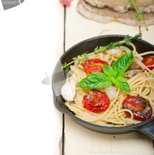 Image of spaghetti pasta with baked cherry tomatoes and basil 