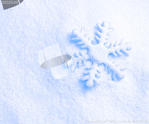 Image of snowflake against a background of snow