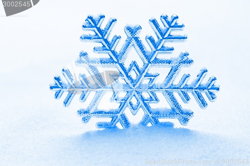 Image of snowflake against a background of snow