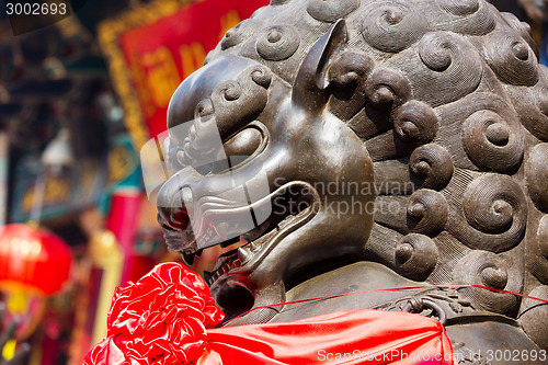 Image of Lion statue in front of chinese temple 