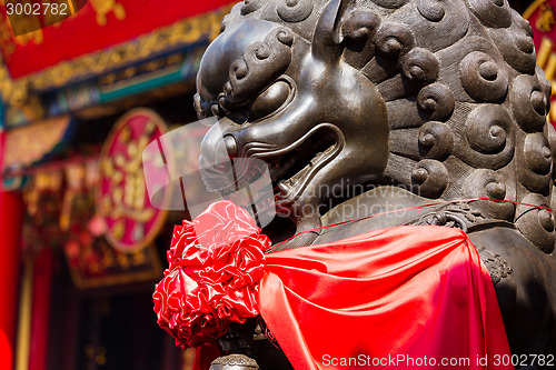 Image of Lion statue in front of chinese temple 