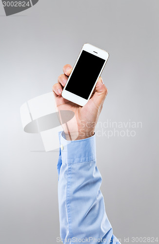 Image of Businessman hold up mobile phone with blank screen