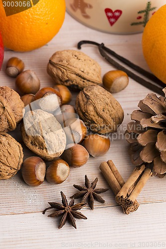 Image of Different kinds of spices, nuts and dried oranges - christmas de