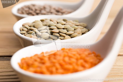Image of Three kinds of lentil in bowls - red lentil, green lentil and br