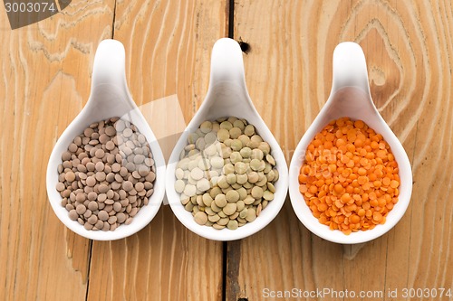 Image of Three kinds of lentil in bowls - red lentil, green lentil and br