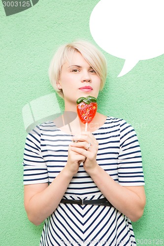 Image of Young sexy woman sucking lollipop. 