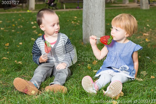 Image of Adorable little kids with colorful lollipops