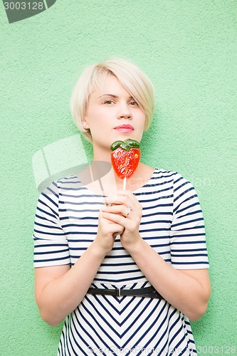 Image of Young sexy woman sucking lollipop. 