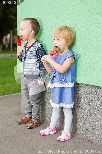 Image of Adorable little kids with colorful lollipops